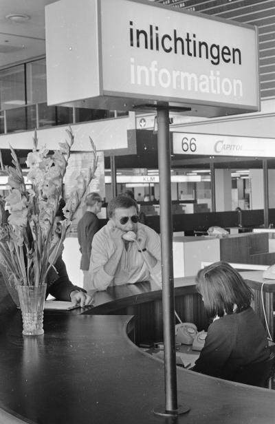 Cuba-gangers wachten op vliegtuig in vertrekhal Schiphol. Schrijver Harry Mulisch.