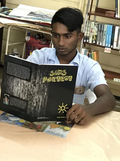 Een muloleerling leest Sams portret van Ismene Krishnadath.